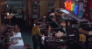 Movie still from “Sleepless in Seattle” (1993), directed by Nora Ephron – People are sitting at tables in a restaurant; Wide shot, High angle