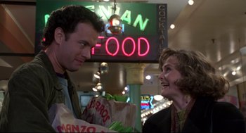 Movie still from “Sleepless in Seattle” (1993), directed by Nora Ephron – A man and a woman talking to each other in front of a neon sign; Medium shot, Over the shoulder angle