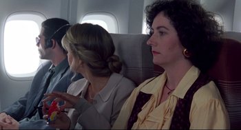 Movie still from “Sleepless in Seattle” (1993), directed by Nora Ephron – Three women are sitting on an airplane and one is holding a cell phone; Close Up shot, High angle