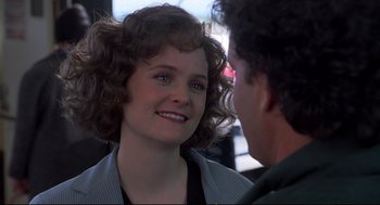 Movie still from “Sleepless in Seattle” (1993), directed by Nora Ephron – A woman smiles at a man in front of a window; Close Up shot, Over the shoulder angle