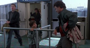 Movie still from “Sleepless in Seattle” (1993), directed by Nora Ephron – A man and a boy are talking to each other in an airport; Medium shot, Over the shoulder angle