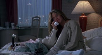 Movie still from “Sleepless in Seattle” (1993), directed by Nora Ephron – A woman sitting on a bed holding a wii controller; Medium shot, High angle