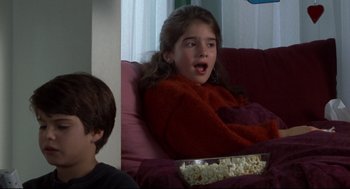 Movie still from “Sleepless in Seattle” (1993), directed by Nora Ephron – A young boy and girl watching a movie; Close Up shot, High angle