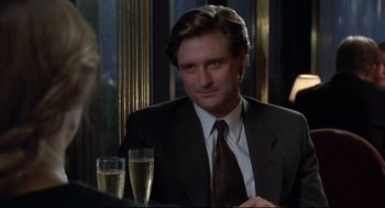 Movie still from “Sleepless in Seattle” (1993), directed by Nora Ephron – A man sitting at a table with champagne; Close Up shot, Over the shoulder angle