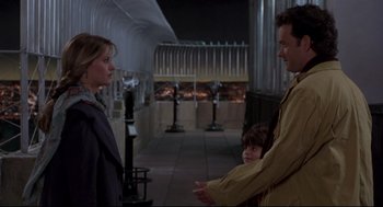 Movie still from “Sleepless in Seattle” (1993), directed by Nora Ephron – A man and a woman talking to a child in front of a fireplace; Medium shot, Over the shoulder angle