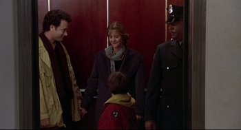 Movie still from “Sleepless in Seattle” (1993), directed by Nora Ephron – A group of people standing next to each other in a room; Medium shot, Over the shoulder angle
