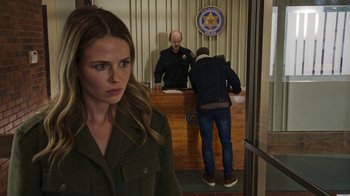 Movie still from “Sniper: Rogue Mission” (2022), directed by Oliver Thompson – A woman standing in front of two men in front of a counter; Medium shot, Over the shoulder angle