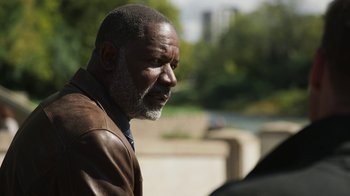 Movie still from “Sniper: Rogue Mission” (2022), directed by Oliver Thompson – An older black man with a beard looking to his left; Close Up shot, Over the shoulder angle