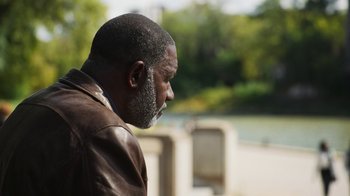 Movie still from “Sniper: Rogue Mission” (2022), directed by Oliver Thompson – A man in a brown leather jacket looking to his left; Close Up shot, Over the shoulder angle