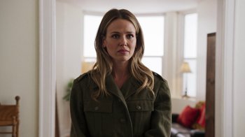 Movie still from “Sniper: Rogue Mission” (2022), directed by Oliver Thompson – A woman in a green jacket standing in front of a window; Close Up shot, Over the shoulder angle