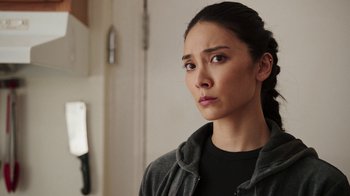 Movie still from “Sniper: Rogue Mission” (2022), directed by Oliver Thompson – A person wearing a jacket; Close Up shot, Over the shoulder angle