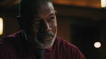 Movie still from “Sniper: Rogue Mission” (2022), directed by Oliver Thompson – A person wearing a red shirt; Close Up shot, Over the shoulder angle