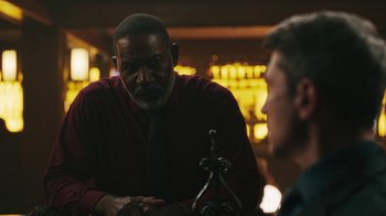 Movie still from “Sniper: Rogue Mission” (2022), directed by Oliver Thompson – A man in a red dress shirt and a man in a black tie; Close Up shot, Over the shoulder angle