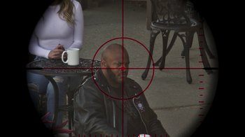 Movie still from “Sniper: Rogue Mission” (2022), directed by Oliver Thompson – A man sitting in front of a woman with a coffee cup; Extreme Close Up shot, High angle