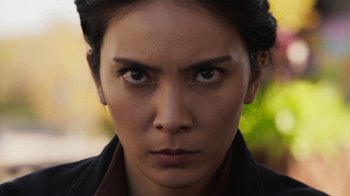 Movie still from “Sniper: Rogue Mission” (2022), directed by Oliver Thompson – A woman's face in a black jacket; Close Up shot, Low angle