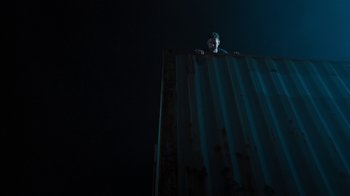 Movie still from “Sniper: Rogue Mission” (2022), directed by Oliver Thompson – A man standing on top of a metal wall; Extreme Wide shot, Low angle