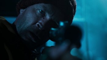 Movie still from “Sniper: Rogue Mission” (2022), directed by Oliver Thompson – A person with a hat on; Extreme Close Up shot, Over the shoulder angle
