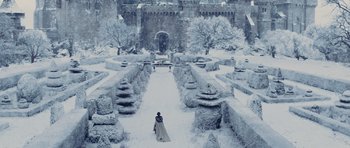 Movie still from “Snow White and the Huntsman” (2012), directed by Rupert Sanders – A man in a long coat standing in the middle of a snow covered garden; Extreme Wide shot, High angle