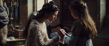 Movie still from “Snow White and the Huntsman” (2012), directed by Rupert Sanders – A woman wearing a crown and holding a ring; Medium shot, Over the shoulder angle