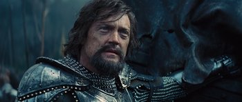 Movie still from “Snow White and the Huntsman” (2012), directed by Rupert Sanders – A person with a beard wearing armor; Close Up shot, Low angle