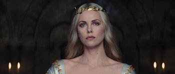 Movie still from “Snow White and the Huntsman” (2012), directed by Rupert Sanders – A woman wearing a gold crown and a white dress; Close Up shot, Low angle