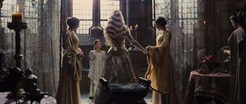 Movie still from “Snow White and the Huntsman” (2012), directed by Rupert Sanders – A group of people standing in a room with candles; Wide shot, Over the shoulder angle