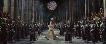 Movie still from “Snow White and the Huntsman” (2012), directed by Rupert Sanders – A woman dressed as a princess in a cathedral surrounded by soldiers; Wide shot, High angle