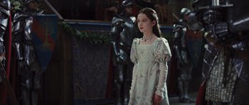 Movie still from “Snow White and the Huntsman” (2012), directed by Rupert Sanders – A young girl in a white dress standing in front of a man in a suit; Medium shot, Over the shoulder angle