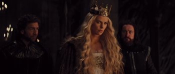 Movie still from “Snow White and the Huntsman” (2012), directed by Rupert Sanders – A woman with long blonde hair wearing a crown; Close Up shot, Over the shoulder angle