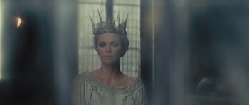 Movie still from “Snow White and the Huntsman” (2012), directed by Rupert Sanders – A woman wearing a crown standing in front of a window; Close Up shot, Low angle