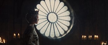 Movie still from “Snow White and the Huntsman” (2012), directed by Rupert Sanders – A woman with a crown standing in front of a stained glass window; Close Up shot, Low angle