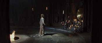 Movie still from “Snow White and the Huntsman” (2012), directed by Rupert Sanders – A man and a woman standing next to each other in front of candles; Wide shot, High angle