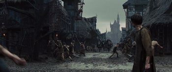 Movie still from “Snow White and the Huntsman” (2012), directed by Rupert Sanders – A group of people are standing in the middle of a city; Extreme Wide shot, High angle