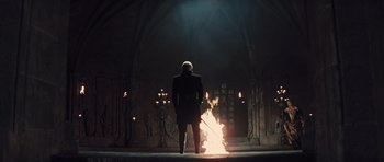 Movie still from “Snow White and the Huntsman” (2012), directed by Rupert Sanders – A man standing in front of a fire in a cathedral; Wide shot, Low angle