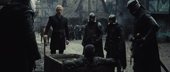 Movie still from “Snow White and the Huntsman” (2012), directed by Rupert Sanders – A group of men standing next to each other in a field; Medium shot, Over the shoulder angle