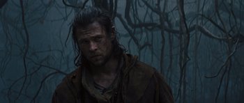 Movie still from “Snow White and the Huntsman” (2012), directed by Rupert Sanders – A person wearing a hooded jacket near a forest; Close Up shot, Low angle