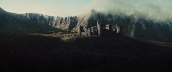 Movie still from “Snow White and the Huntsman” (2012), directed by Rupert Sanders – A large castle on top of a hill with mountains in the background; Extreme Wide shot, High angle