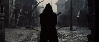 Movie still from “Snow White and the Huntsman” (2012), directed by Rupert Sanders – A person holding a bow and arrow in the dark; Wide shot, Over the shoulder angle