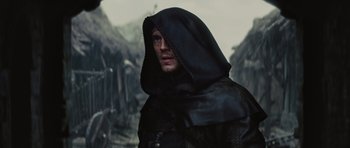 Movie still from “Snow White and the Huntsman” (2012), directed by Rupert Sanders – A man wearing a black hood and a black jacket; Close Up shot, Over the shoulder angle