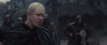 Movie still from “Snow White and the Huntsman” (2012), directed by Rupert Sanders – A man with blonde hair and a black outfit; Close Up shot, Over the shoulder angle