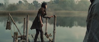 Movie still from “Snow White and the Huntsman” (2012), directed by Rupert Sanders – A woman standing on a dock near the water; Wide shot, Over the shoulder angle