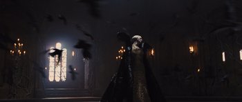 Movie still from “Snow White and the Huntsman” (2012), directed by Rupert Sanders – A woman dressed in a black and gold dress; Wide shot, Low angle