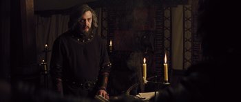 Movie still from “Snow White and the Huntsman” (2012), directed by Rupert Sanders – A man with a long beard standing in front of candles; Medium shot, Low angle