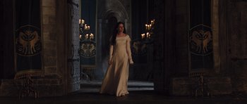 Movie still from “Snow White and the Huntsman” (2012), directed by Rupert Sanders – A woman in a white dress standing in front of candles in a room; Wide shot, Low angle