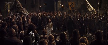 Movie still from “Snow White and the Huntsman” (2012), directed by Rupert Sanders – A crowd of people standing around a woman in a white dress; Wide shot, Over the shoulder angle