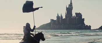 Movie still from “Snow White and the Huntsman” (2012), directed by Rupert Sanders – A person riding a horse in the water with a castle in the background; Extreme Wide shot, Low angle