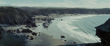 Movie still from “Snow White and the Huntsman” (2012), directed by Rupert Sanders – A painting of a beach with people walking on the beach; Extreme Wide shot, High angle