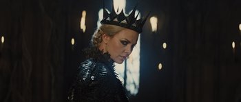 Movie still from “Snow White and the Huntsman” (2012), directed by Rupert Sanders – A woman wearing a black leather jacket and a crown; Close Up shot, Low angle