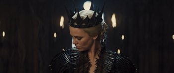 Movie still from “Snow White and the Huntsman” (2012), directed by Rupert Sanders – A woman wearing a black leather jacket and a crown; Close Up shot, Low angle