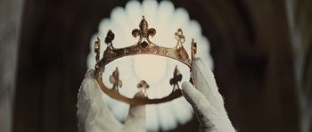 Movie still from “Snow White and the Huntsman” (2012), directed by Rupert Sanders – A person holding a crown in front of a window; Extreme Close Up shot, Low angle
